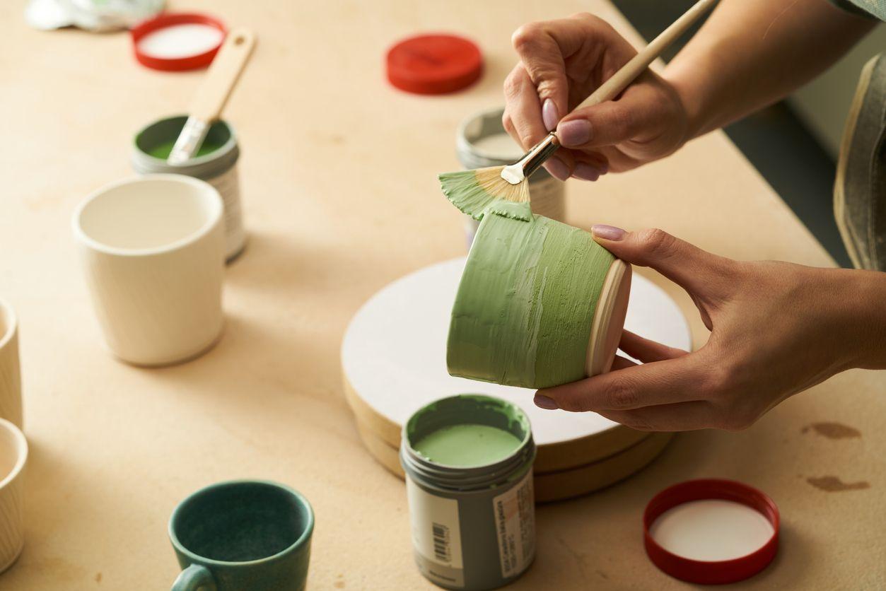 A woman painting a plant pot