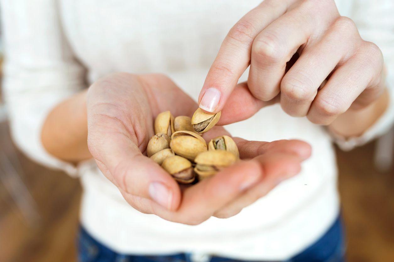 A woman holding pistachio nuts