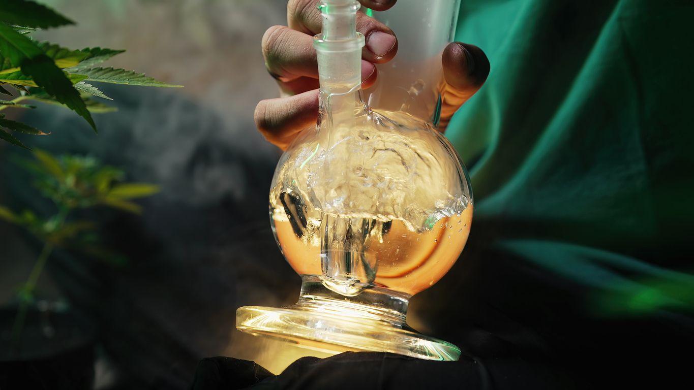 Person using a glass water bong